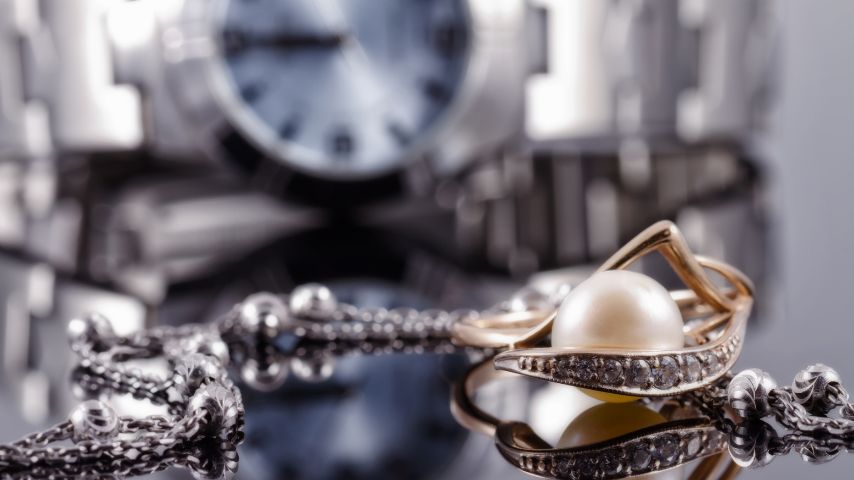 Stylowa biżuteria do zegarka, a w tle elegancki zegarek.