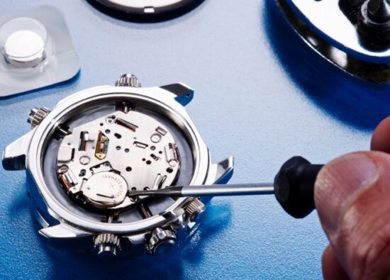 Jak wymienić baterię w zegarku? Na zdjęciu zegarmistrz wymienia baterię w zegarku.