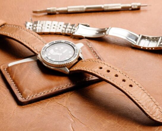Jak wymienić pasek w zegarku? Na zdjęciu zegarek ze skórzanym paskiem po wymianie z leżącej obok bransolety.