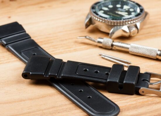 Czarny pasek gumowy do zegarka zdjęty z metalowego zegarka.