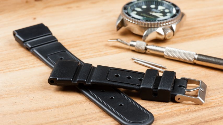Czarny pasek gumowy do zegarka zdjęty z metalowego zegarka.