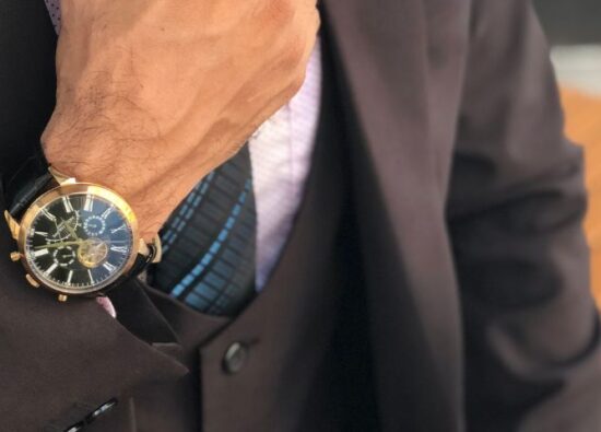 Mężczyzna nosi na nadgarstku elegancki zegarek do garnituru.