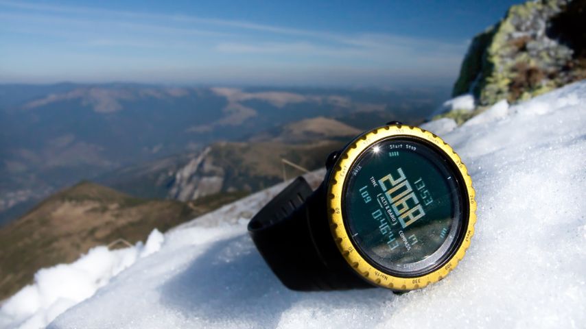 Zegarek z barometrem na śniegu w górach.