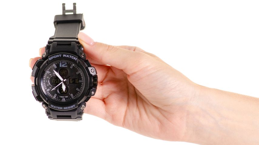 Kobieta prezentuje, jak wyglądają typowe zegarki G-shock. Na zdjęciu czarny zegarek tej marki.