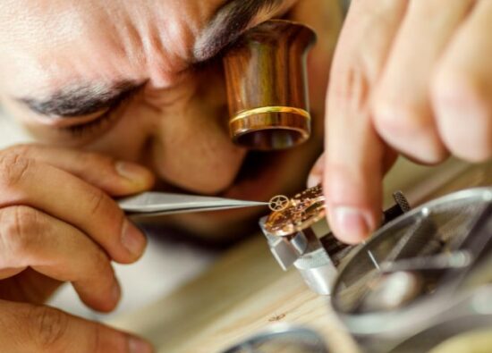 Zegarmistrz naprawia zniszczony zegarek za pomocą specjalnych narzędzi.