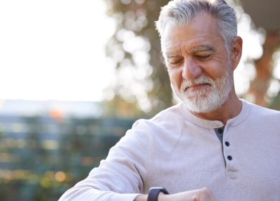 Starszy mężczyzna patrzy na swój zegarek dla seniora.